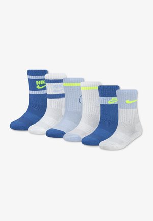 Six paires de chaussettes montantes Nike en bleu, blanc et gris clair avec des rayures et logos de couleurs variées, disposées en une rangée sur un fond blanc.