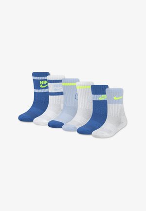 Six paires de chaussettes montantes Nike en bleu, blanc et gris clair avec des rayures et logos de couleurs variées, disposées en une rangée sur un fond blanc.
