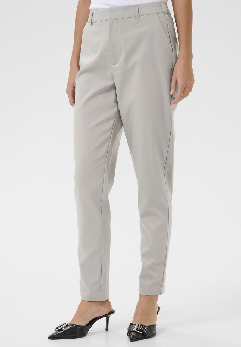 Světlé šedé kalhoty na míru vyrobené z hladké tkaniny se slim fit střihem, vybavené bočními kapsami a skrytým předním zapínáním.