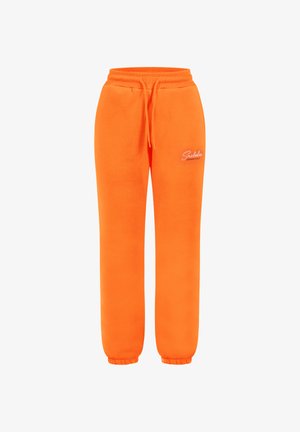 Pantalons de survêtement orange en matériau doux, avec une taille à cordon, des poignets élastiques et un petit logo de marque blanc sur la cuisse gauche.