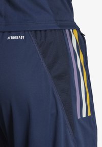 Pantalones cortos deportivos de color navy con el logo de AEROREADY, presentando paneles laterales de malla y rayas verticales en púrpura, amarillo y blanco en la pierna.