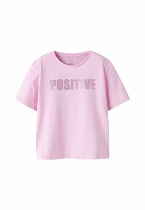 T-shirt rose clair à manches courtes avec col rond, arborant le mot "POSITIVE" en lettres perforées en points sur la poitrine.