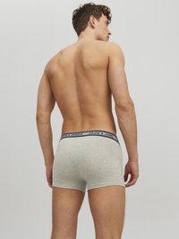 Graue Baumwoll-Boxer-Shorts mit einem marineblauen Bund, auf dem der Text "JACK & JONES" sichtbar ist. Glatte Textur und figurbetontes Design.