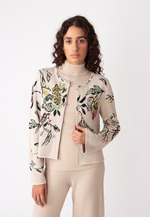 Gebreide cardigan in crème met florale borduursels in groen, geel en roze. Heeft een ronde halslijn en aansluitende mouwen.