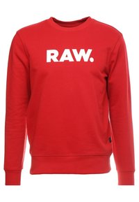 Felpa rossa con scollo a girocollo, polsini e orlo ribattuti, con un audace logo bianco "RAW." stampato sul petto. Realizzata in un morbido mix di cotone.