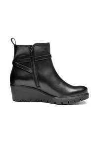 Stivale alla caviglia in pelle nera con suola a zeppa, cerniera laterale e cinturino decorativo, progettato per abbigliamento casual o semi-formale.