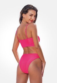 Rosa Bikiniset mit einem angepassten, cropped Oberteil und hoch geschnittenen Hosen. Hergestellt aus glattem, dehnbarem Material. Verfügt über dünne Träger und minimale Bedeckung.