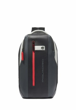 Schwarzer und grauer Rucksack mit glatter Textur, der einen auffälligen roten Reißverschluss und Logodetails aufweist. Schlanke, rechteckige Form mit verstellbaren Trägern.