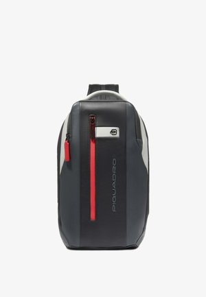 Black and gray backpack with a smooth texture, featuring a prominent red zipper and logo detail. Slim, rectangular shape with adjustable straps.