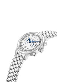 Silverfärgad metallkronograf med vit urtavla, blå visare, två sub-dialer och ett strukturerat stålarmband. Har ett datumfönster vid 6.