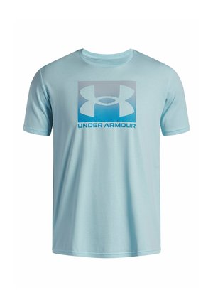 T-shirt bleu clair à manches courtes avec un grand logo Under Armour et un texte bleu centré sur la poitrine.