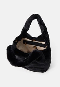 Sort faux fur håndtaske med en blød tekstur, robuste håndtag og en lynlåslomme indeni. Indvendigt har den en foring med logo-mønster.
