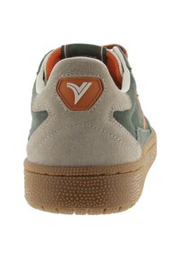 Sneaker verde e beige con un design a strati in suede e pelle, caratterizzata da un accento arancione e una suola in gomma testurizzata per una migliore aderenza.