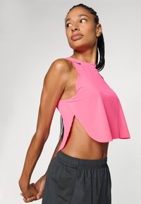 Rosa, kurzfristiger Tank-Top mit hohem Ausschnitt, offenen Seiten und gerippter Textur, kombiniert mit Shorts aus schwarzem elastischem Bund.