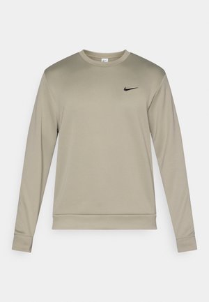 Light beige long-sleeve sweatshirt with crew neck, featuring a black Nike logo on the upper left. Made from smooth, stretchy fabric.