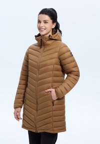 Lange bruin pufferjas met een capuchon, voorzien van diagonale quiltpatronen, een rits aan de voorkant en twee zijzakken. Glad textuur en getailleerd ontwerp.