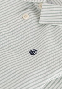 Camicia a strisce verde chiaro e bianco realizzata in morbido tessuto, con ricamo del logo blu navy e bottoni in plastica sul colletto.