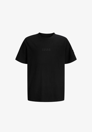 Czarna bawełniana koszulka z okrągłym dekoltem i subtelnym logo, zestawiona z czarnymi spodniami i białymi trampkami, na neutralnym tle.