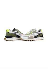 Zapatillas multicolores con parte superior de malla gris, acentos de ante negro y verde, detalles amarillos y suela de goma beige.