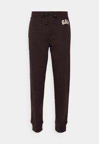Braune Baumwoll-Sweatpants mit elastischem Bund und Kordelzug. Verfügt über das "GAP"-Logo in heller Farbe. Die Bündchen an den Knöcheln runden das Design ab.
