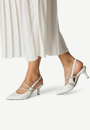 Escarpins slingback blancs à bouts pointus, ornés de fines lanières et dotés d'un talon de hauteur moyenne. Texture en cuir lisse et design minimaliste.