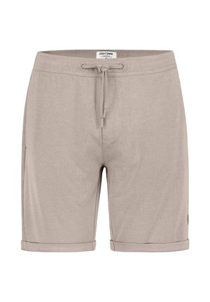 Hellbeige legere Shorts mit Kordelzugbund, aufgeschlagenen Säumen und einem kleinen Stoffetikett an der Seite.