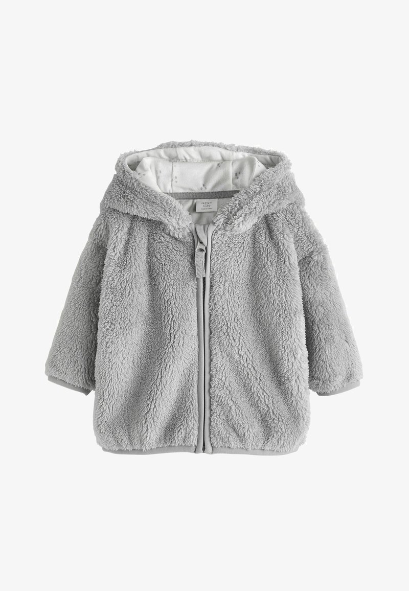 Szürke bolyhos dzseki, puha tapintással, elől cipzáros záródással és kapucnival. Az élein kontrasztos díszítéssel és bélelt belső résszel rendelkezik.