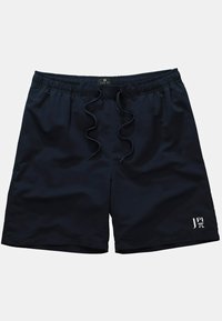 Bañador azul marino con cinturilla elástica, cierre con cordón y un discreto detalle de logo en el dobladillo. Tejido ligero y con textura.