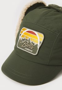 Grønn caps med et mykt, fôret innvendig og en avrundet skygge. Har et brodert merker med et fjell og solnedgangsdesign.
