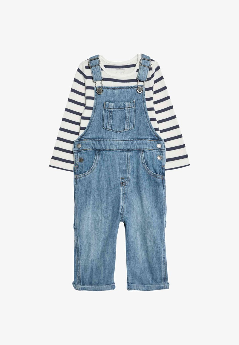 Lichtblauwe denim overalls met verstelbare schouderbanden, zilveren hardware en een borstzak, gecombineerd met een marineblauw en wit gestreept shirt met lange mouwen.