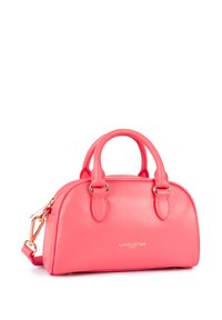 Sac à main en cuir rose avec un corps rond, double anse supérieure, quincaillerie dorée et bandoulière amovible ; présente le logo de la marque à l'avant.