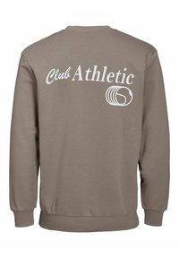 Felpa di colore marrone chiaro con maniche lunghe, polsini e orlo a costine. "Club Athletic" stampato in bianco sul retro con un accento grafico.