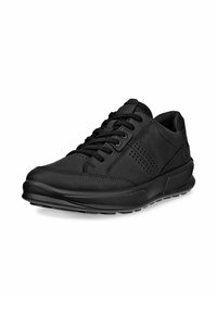 Baskets de sport noires avec une finition en cuir lisse, bout rond, fermeture à lacets, accents perforés et semelle en caoutchouc texturée.
