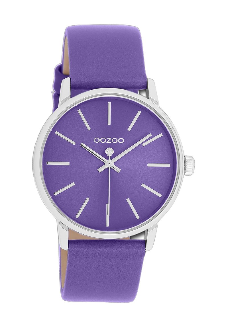 Purple silicone strap watch with a round purple dial, silver hour markers, and minimalist design. Features a silver crown on the side.