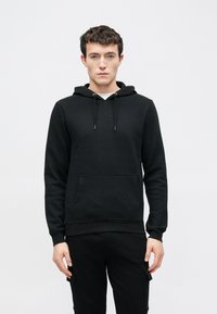 Zwarte pullover hoodie gemaakt van een katoenmenging, voorzien van een buidelzak, capuchon met trekkoord en geribbelde boorden aan mouwen en zoom, met een gladde textuur.