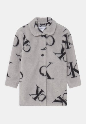 Manteau long à manches longues en fausse fourrure gris clair avec un grand motif logo "CK" noir et fermeture à boutons sur le devant.