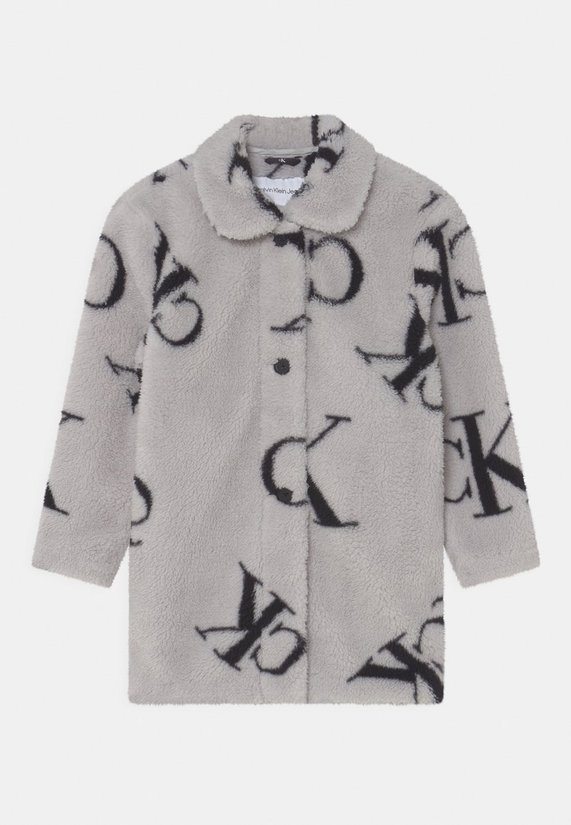 Manteau long à manches longues en fausse fourrure gris clair avec un grand motif logo "CK" noir et fermeture à boutons sur le devant.