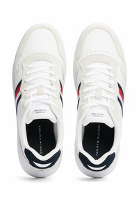 Sneakers bianchi con dettagli in camoscio blu navy e rosso. Caratteristiche includono una punta perforata, chiusura con lacci e suole imbottite per il comfort.