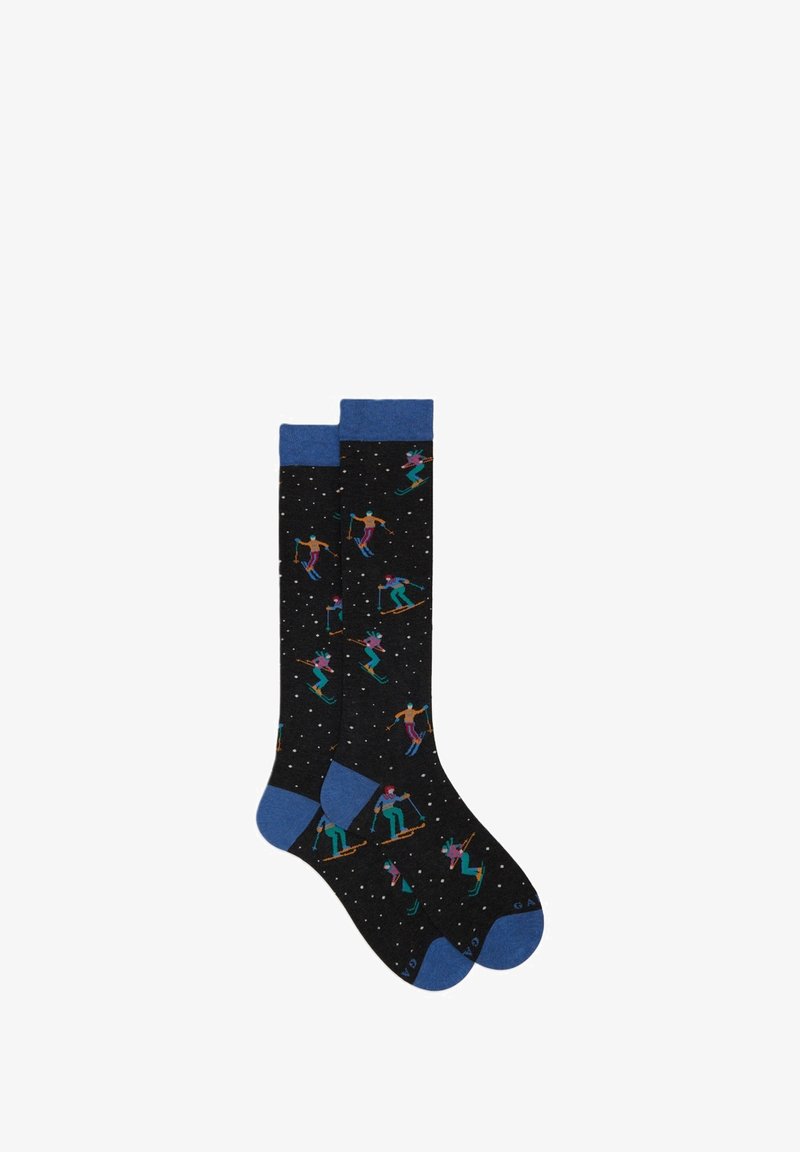 Calze nere fino al ginocchio con risvolti a coste blu, caratterizzate da motivi di sciatore colorati e macchie bianche che assomigliano alla neve. Materiale morbido e elasticizzato.