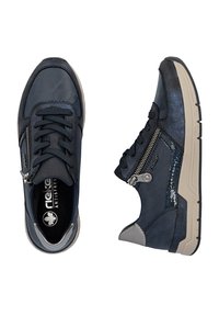 Paire de baskets bleu marine avec lacets noirs, fermetures éclair latérales et semelles beiges, vues de dessus et de côté sur fond blanc.