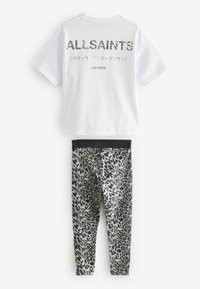 Hvid bomulds t-shirt med "ALLSAINTS" trykt på ryggen i et tekstureret design. Sorte og grå leopardprint leggings med elastisk talje.