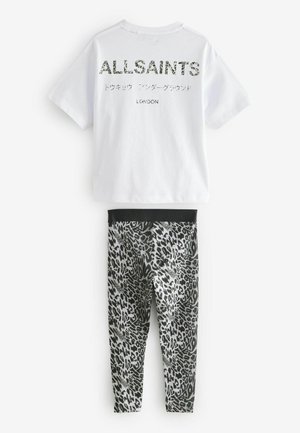 Vit bomullströja med "ALLSAINTS" tryckt på ryggen i en texturerad design. Svart och grå leopardmönstrade leggings med elastisk midja.