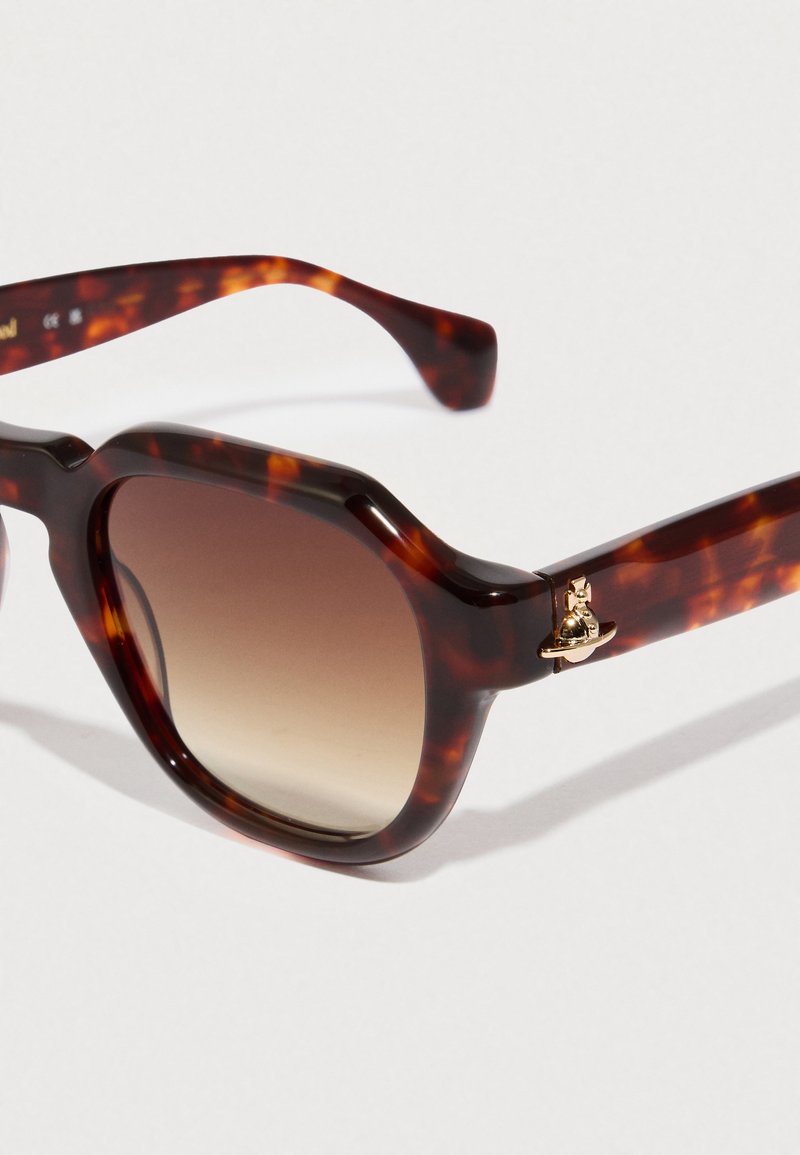 Occhiali da sole tartarugati con montatura ottagonale, lenti marroni sfumate, finitura lucida e dettaglio dorato sulla astina.