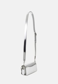 Borsa a tracolla argento con finitura liscia e riflettente. Dotata di una lunga tracolla regolabile e di una chiusura superiore con cerniera, con un piccolo tag attaccato.