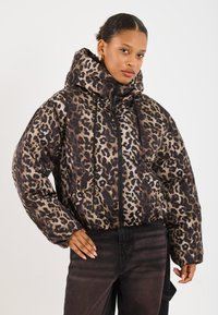 Læderjakke med leopardprint, polstret design, høj krave og frontlynlås. Har elastiske manchetter og sidelommer.