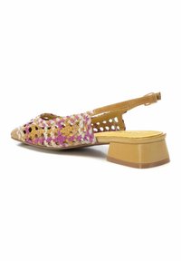 Zapato tipo slingback tejido, con material multicolor en rosa, beige y amarillo, con un tacón bajo y diseño de punta abierta.