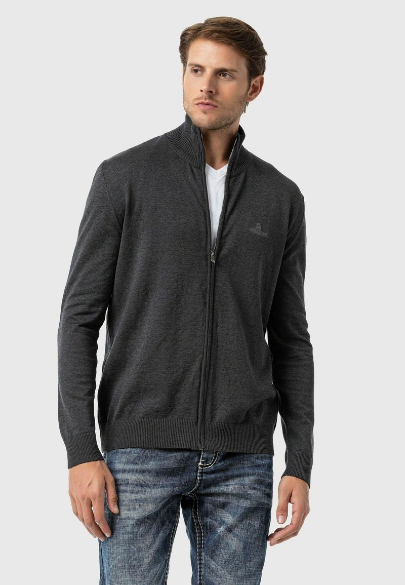 Dunkelgrau zip-up Herren Cardigan aus weichem Strickmaterial. Mit hohem Kragen, gerippten Bündchen und Saum, sowie dezentem Branding auf der Brust.