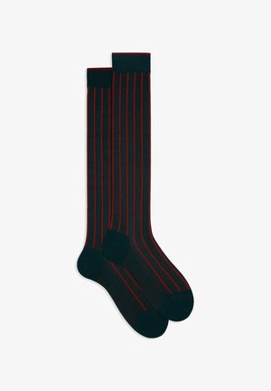 Calze nere fino al ginocchio con strisce verticali rosse, caratterizzate da una punta e un risvolto scuri. Realizzate in un tessuto liscio ed elastico.