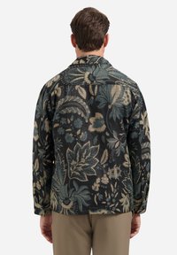 Donker shirt met bloemmotief in zwart, met teal en beige botanische ontwerpen. Lange mouwen en een klassieke kraag. Getextureerde stof.