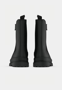 Botas pretas de tornozelo com um acabamento mate suave, design de cano alto, abas de puxar e solas de borracha robustas, apresentando o logótipo no calcanhar traseiro.